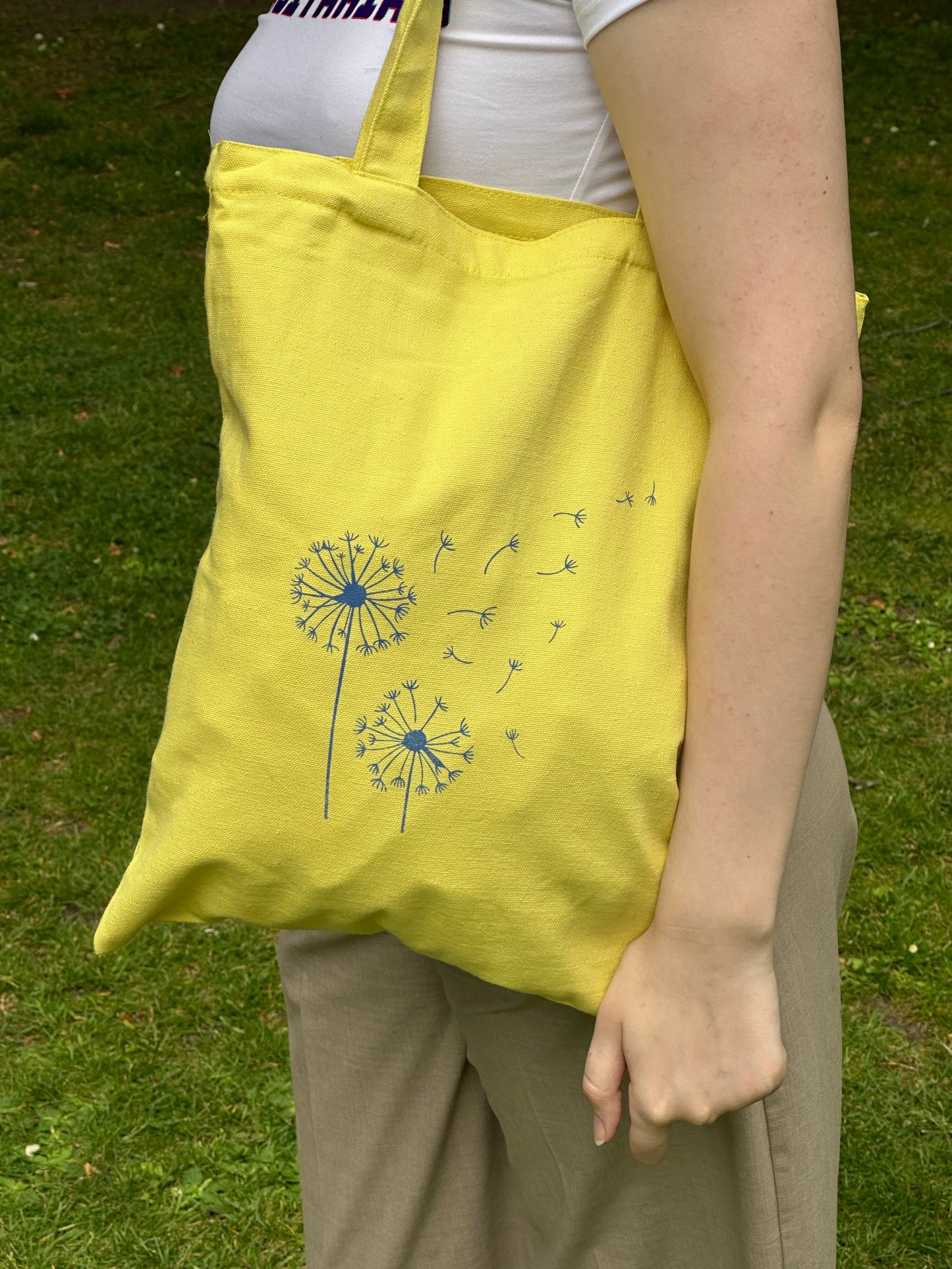 Yellow canvas tote bag with blue dandelion print, designed by Tantrm