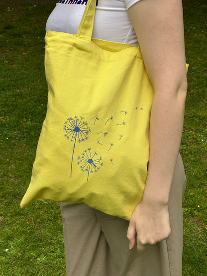 Yellow canvas tote bag with blue dandelion print, designed by Tantrm